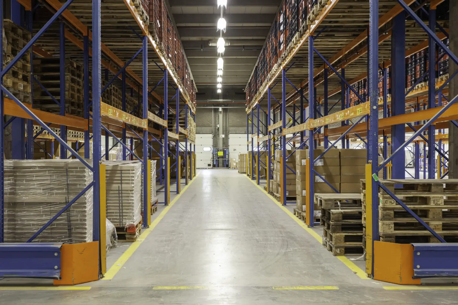 Spacious fulfillment warehouse in Singapore with blue shelving racks and palletized goods