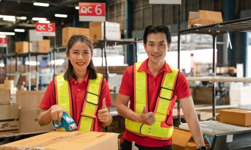 Portrait of staff worker standing in warehouse with his arm crossed looking at camera.